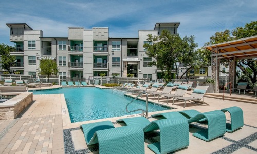 pool with reclining seats and nearness to apartments