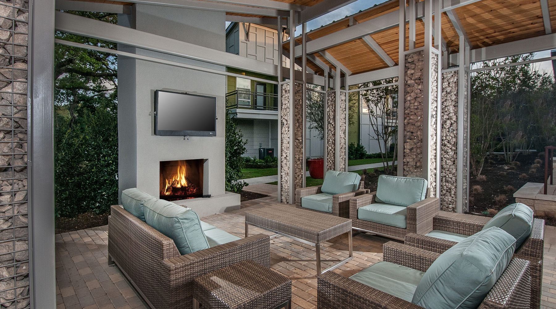 an outdoor patio with a fireplace and media area